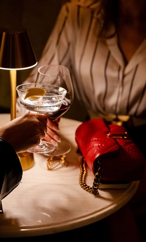 Order Of The Ace, luxurious drinks at a stylish bar, elegant cocktail glass with lemon twist, upscale ambiance, sophisticated social scene, perfect for special occasions and nightlife.